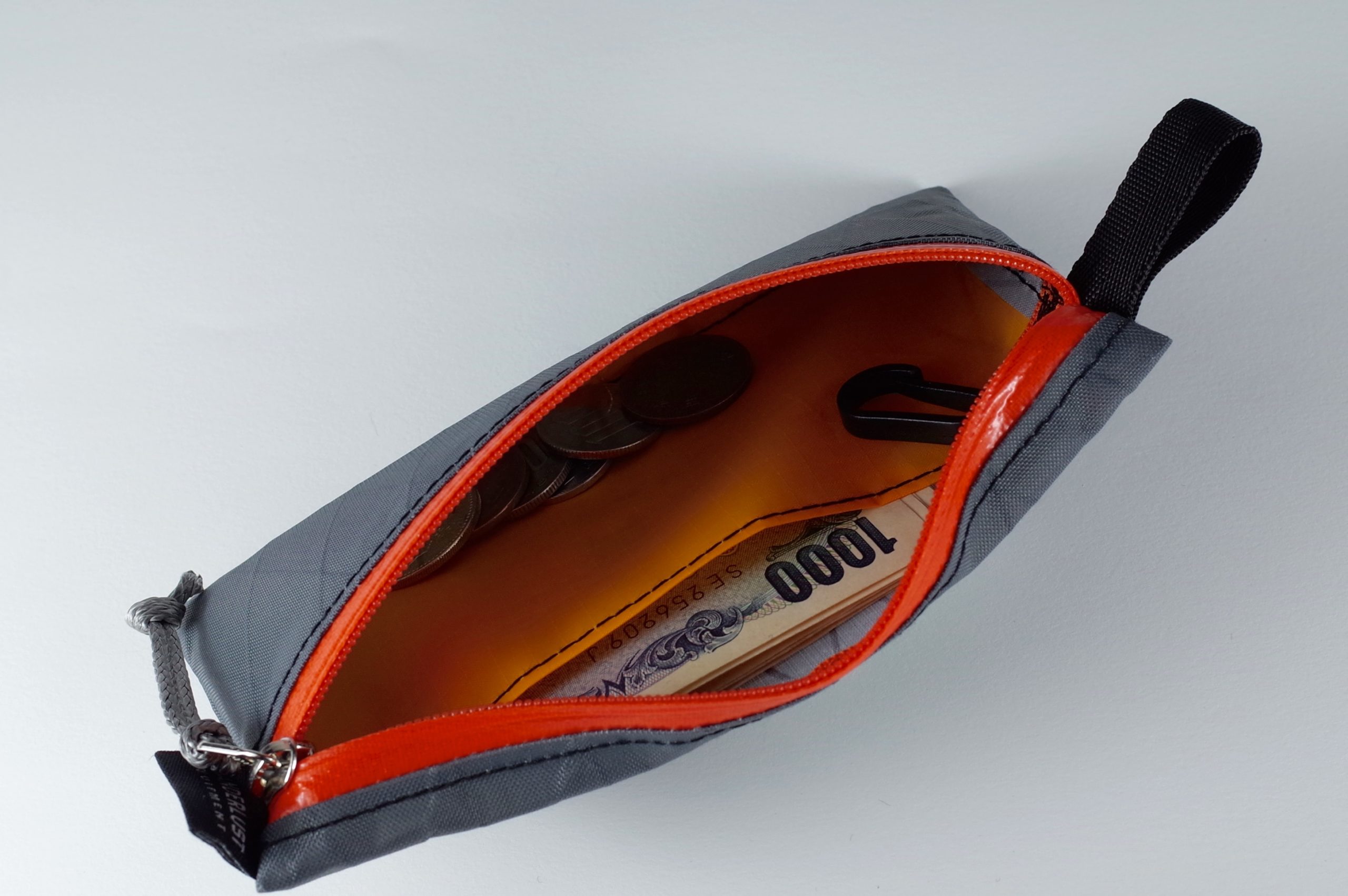 大きく開くジッパー部。仕切りとキーフックを装備